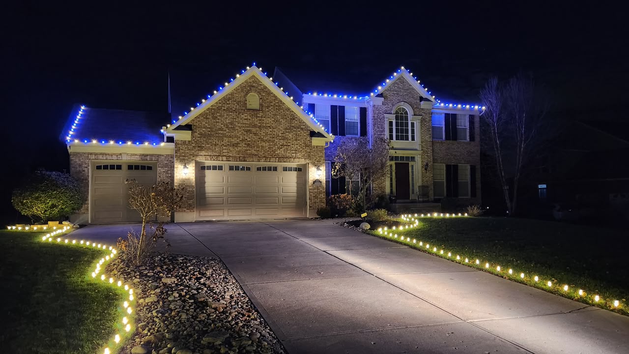 Same Cincinnati home after MerryGlow Christmas light installation — roofline and pathway